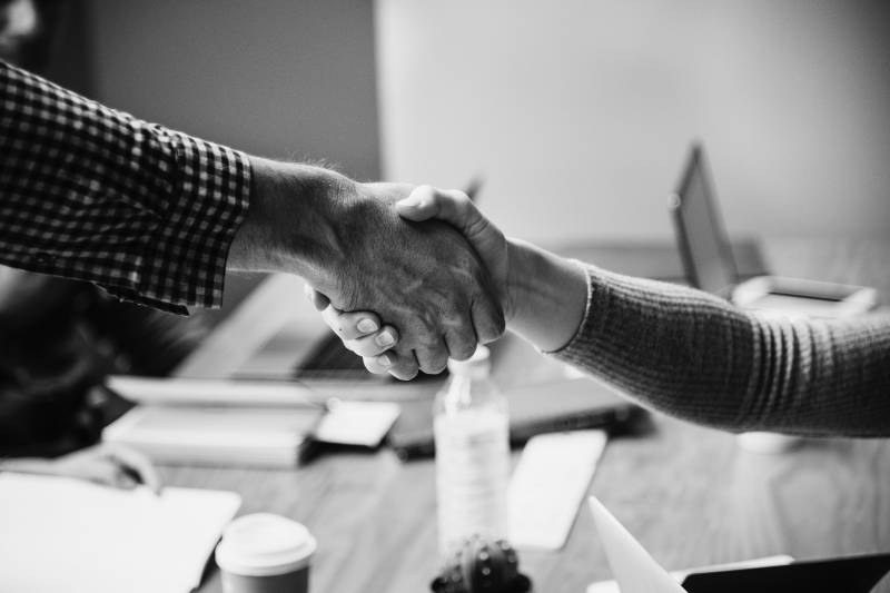 A black and white photo of two people shaking hands